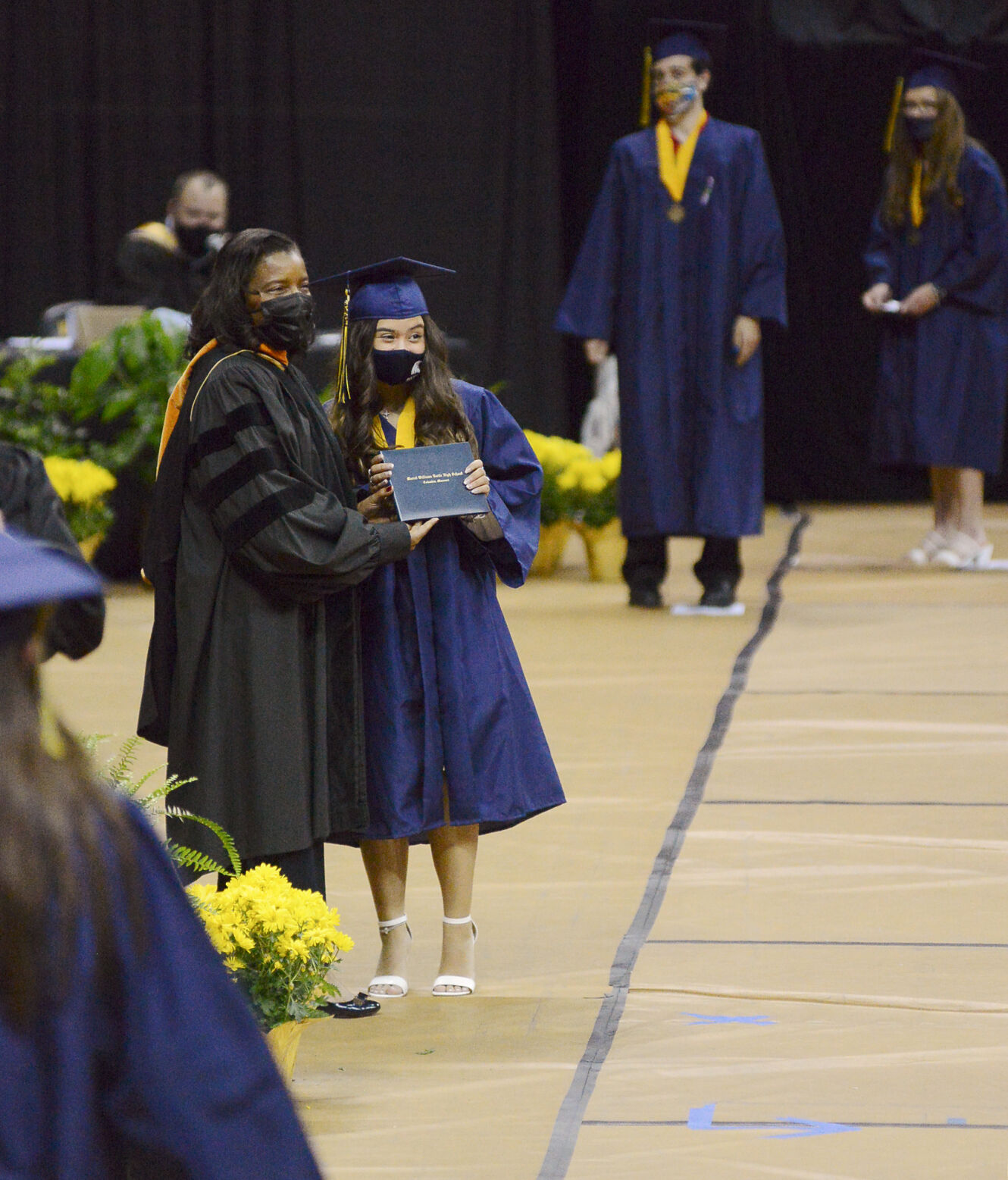 Bri Nguyen walks across the gym floor to receive her diploma